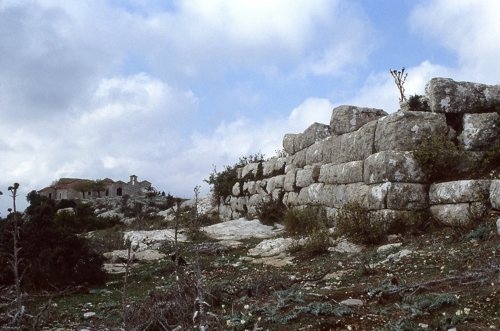 An ancient stone wall on Mount Ithome with the Old Voulkano monastery beyond.