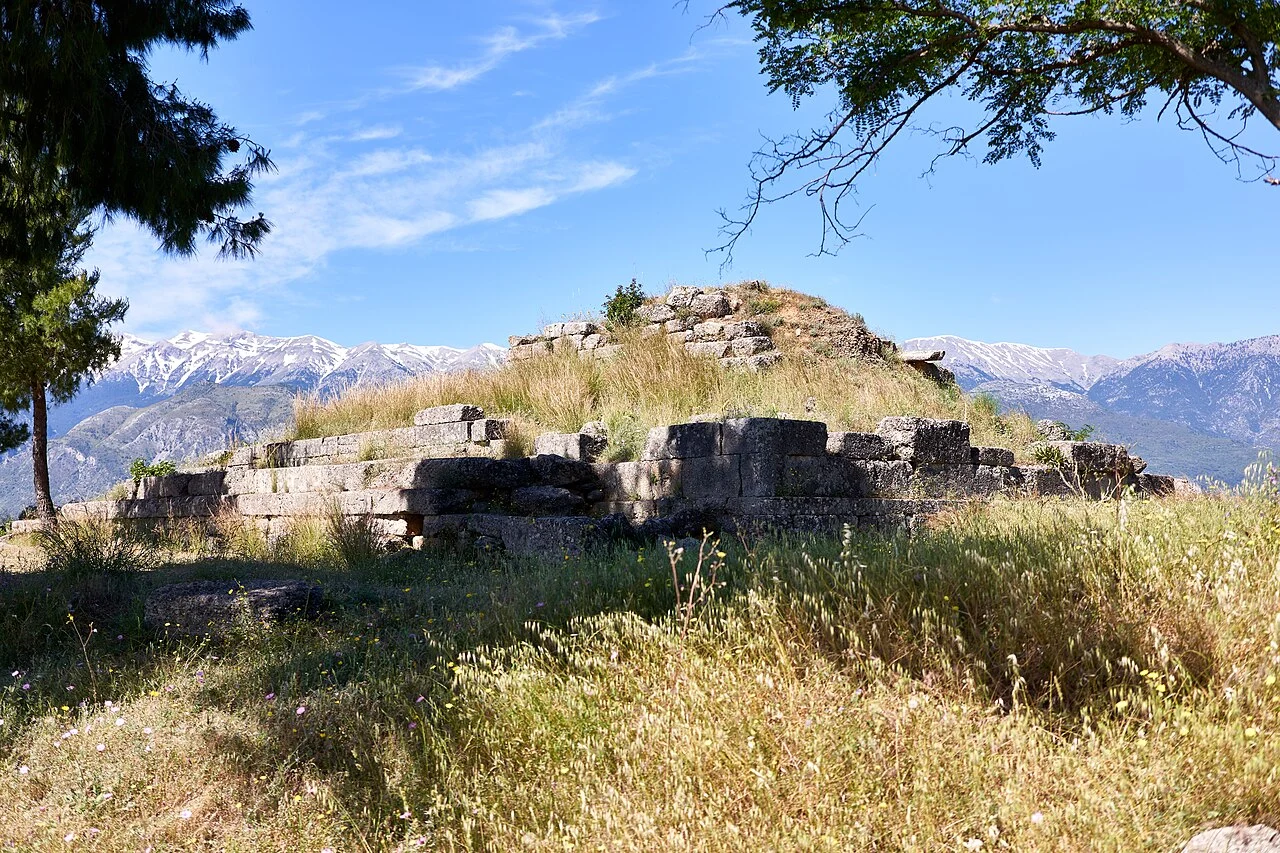 Stone sanctuary remains framed by a tree, with Taygetus beyond